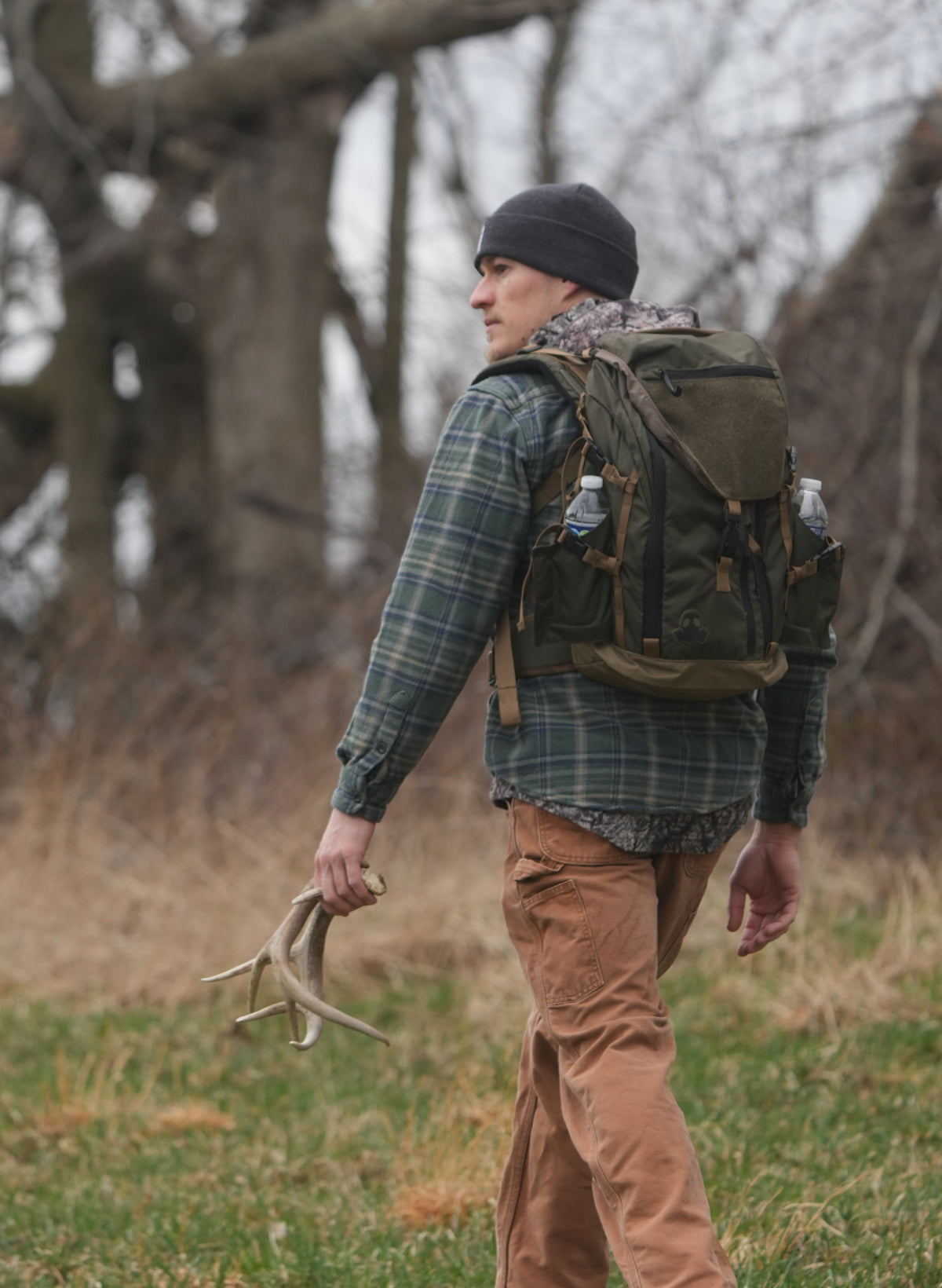 Man with a NSG backpack holding antlers in a natural setting